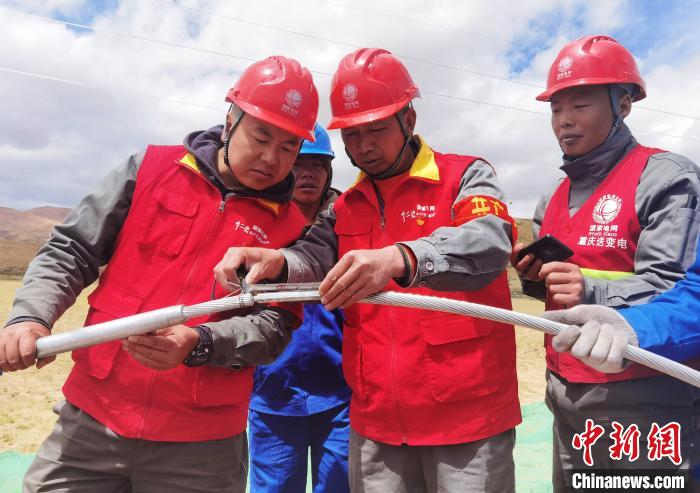 图为阿里与藏中电网联网工程包11标段项目部员工正在测量导线压接尺寸。　张弛 摄